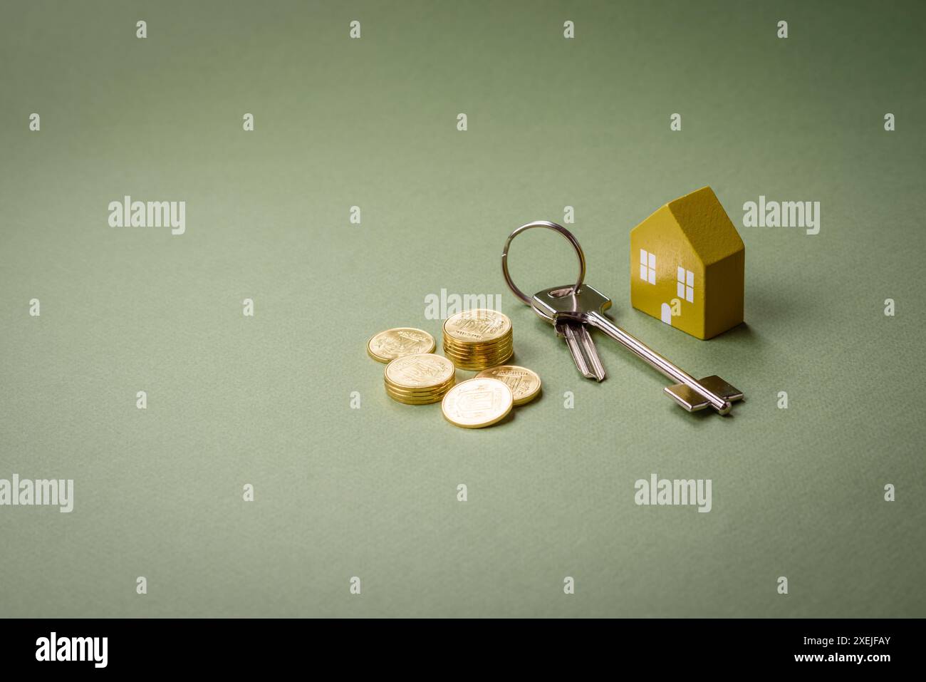 Una piccola casa di legno e chiavi come idea per investire nella propria casa e raggiungere l'obiettivo di acquistare immobili. Sfondo Foto Stock