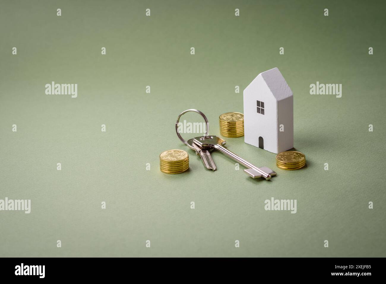 Una piccola casa di legno e chiavi come idea per investire nella propria casa e raggiungere l'obiettivo di acquistare immobili. Sfondo Foto Stock