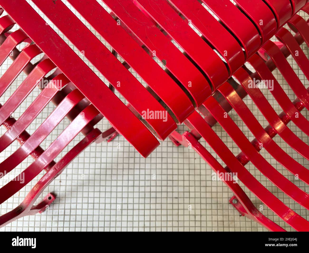 Tavolo e sedie da esterno in metallo laccato rosso su piastrelle quadrate bianche Foto Stock