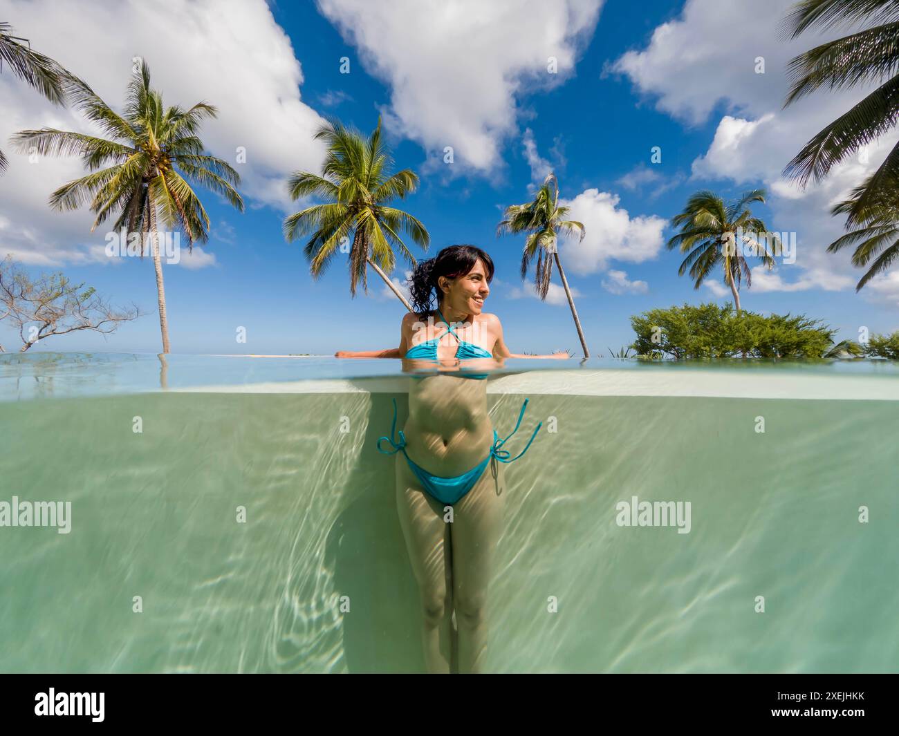 Un bel modello Latino gode Di Una piscina di giorno vicino al Mar dei Caraibi Foto Stock