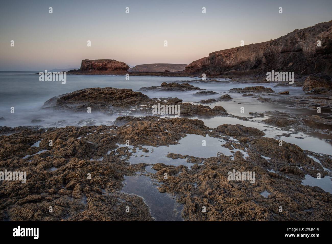 Alba sull'Atlantico. Spiaggia di pietra su un'isola vulcanica, Fuerteventura, Isole Canarie Foto Stock