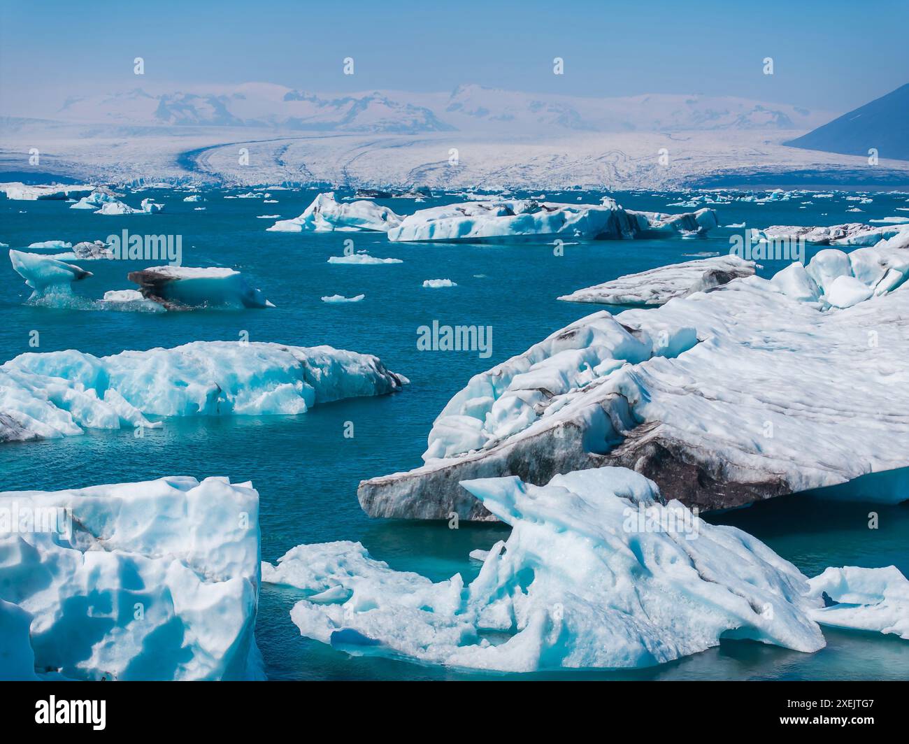 Vista aerea dei grandi pezzi di ghiaccio dal ghiacciaio, dalle isole di ghiaccio, dal ghiacciaio e dalle montagne, Jokulsarlon Foto Stock