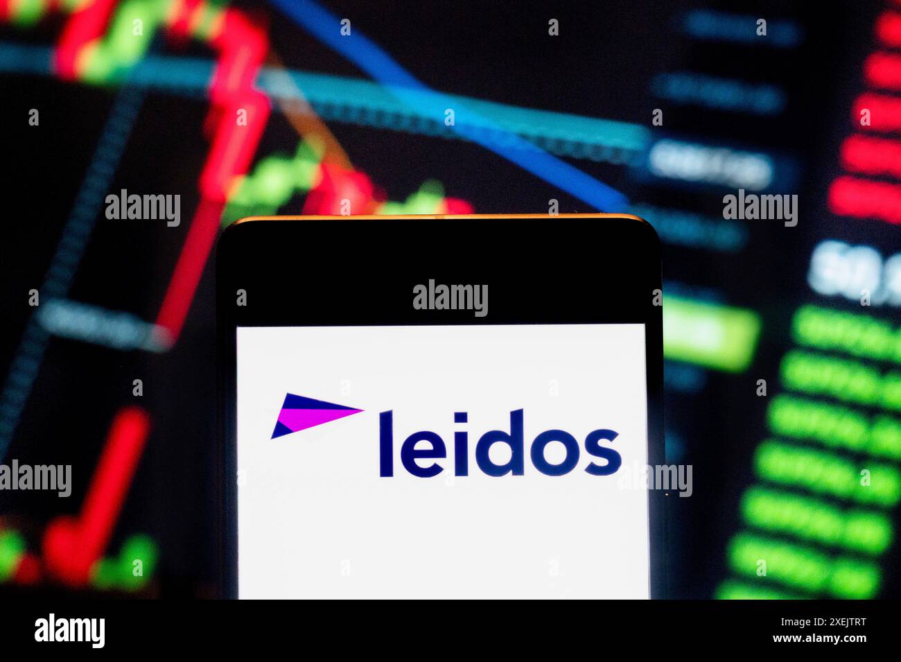 Cina. 21 giugno 2024. In questa illustrazione fotografica, il logo della società americana di difesa, aviazione, tecnologia dell'informazione e ricerca biomedica precedentemente nota come SAIC, Leidos (NYSE: LDOS), visualizzato su uno smartphone con un grafico dell'indice di borsa economica sullo sfondo. Credito: SOPA Images Limited/Alamy Live News Foto Stock