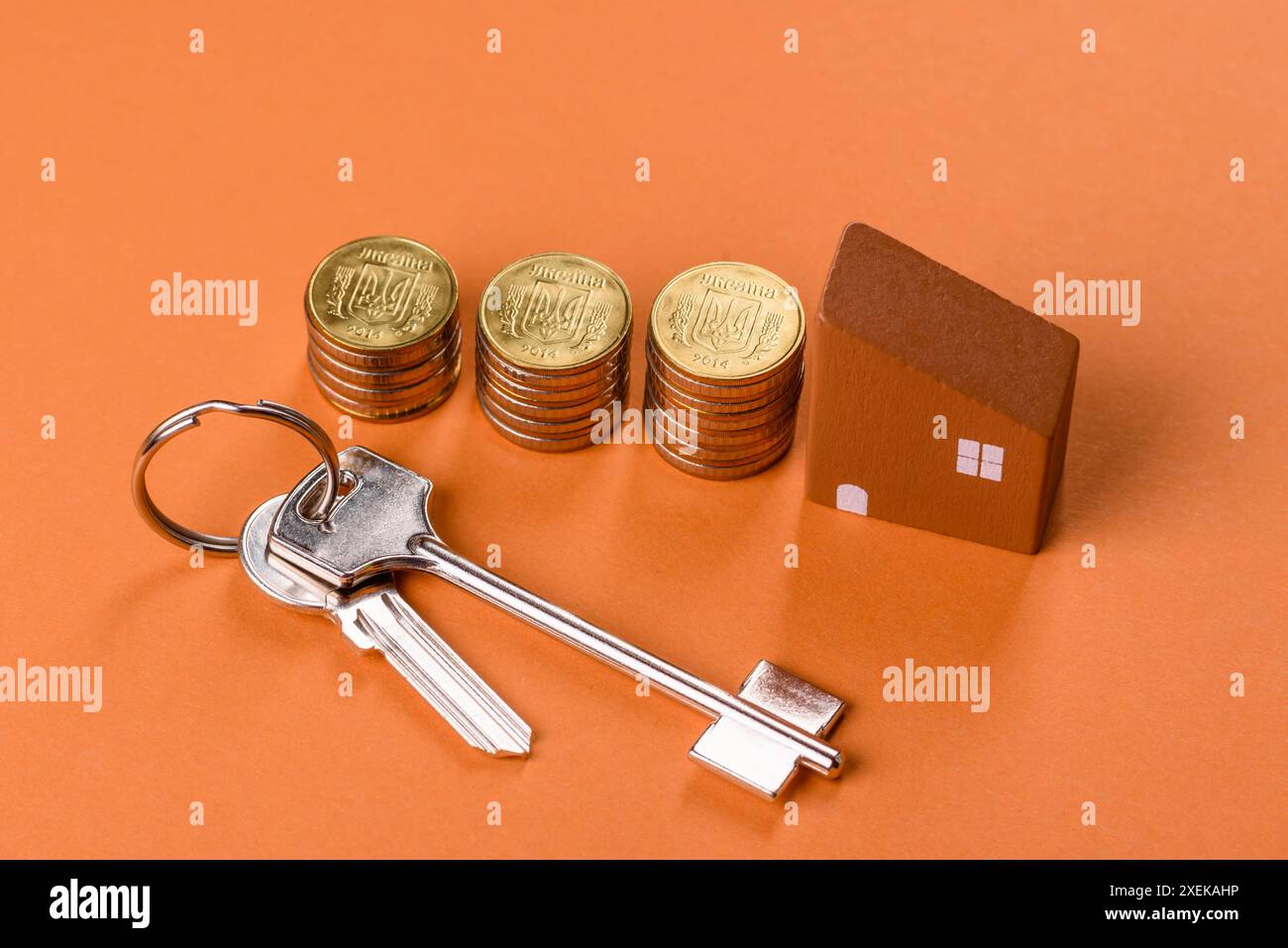 Una piccola casa di legno, soldi e chiavi come idea per investire nella propria casa Foto Stock