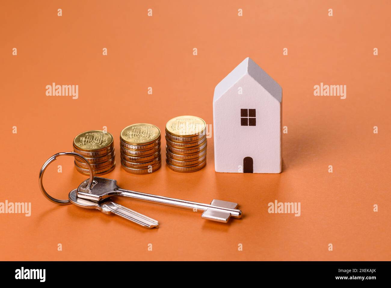 Una piccola casa di legno, soldi e chiavi come idea per investire nella propria casa Foto Stock