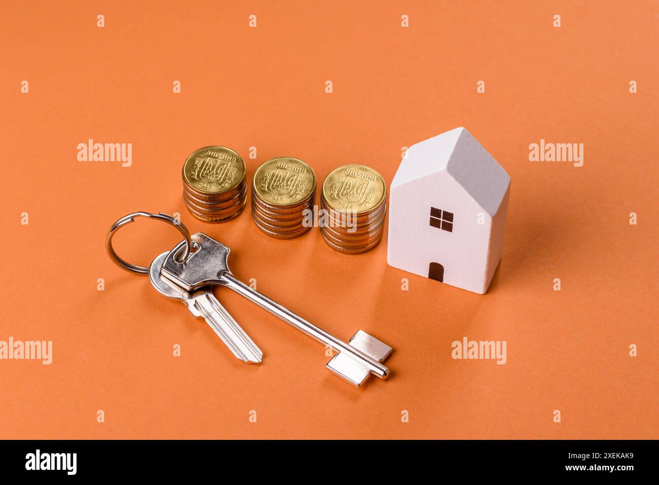 Una piccola casa di legno, soldi e chiavi come idea per investire nella propria casa Foto Stock