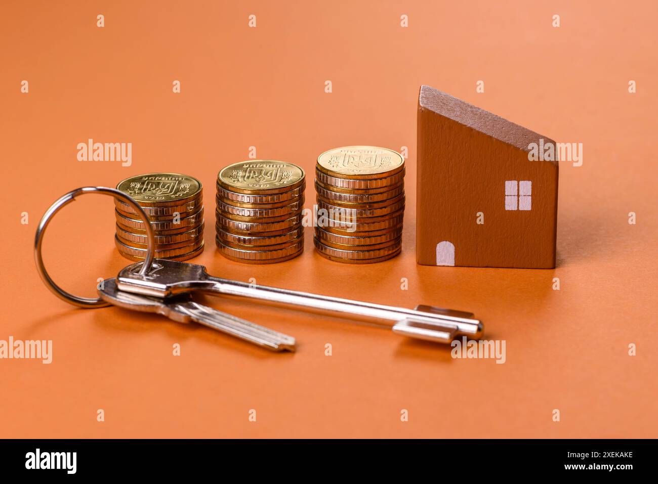 Una piccola casa di legno, soldi e chiavi come idea per investire nella propria casa Foto Stock