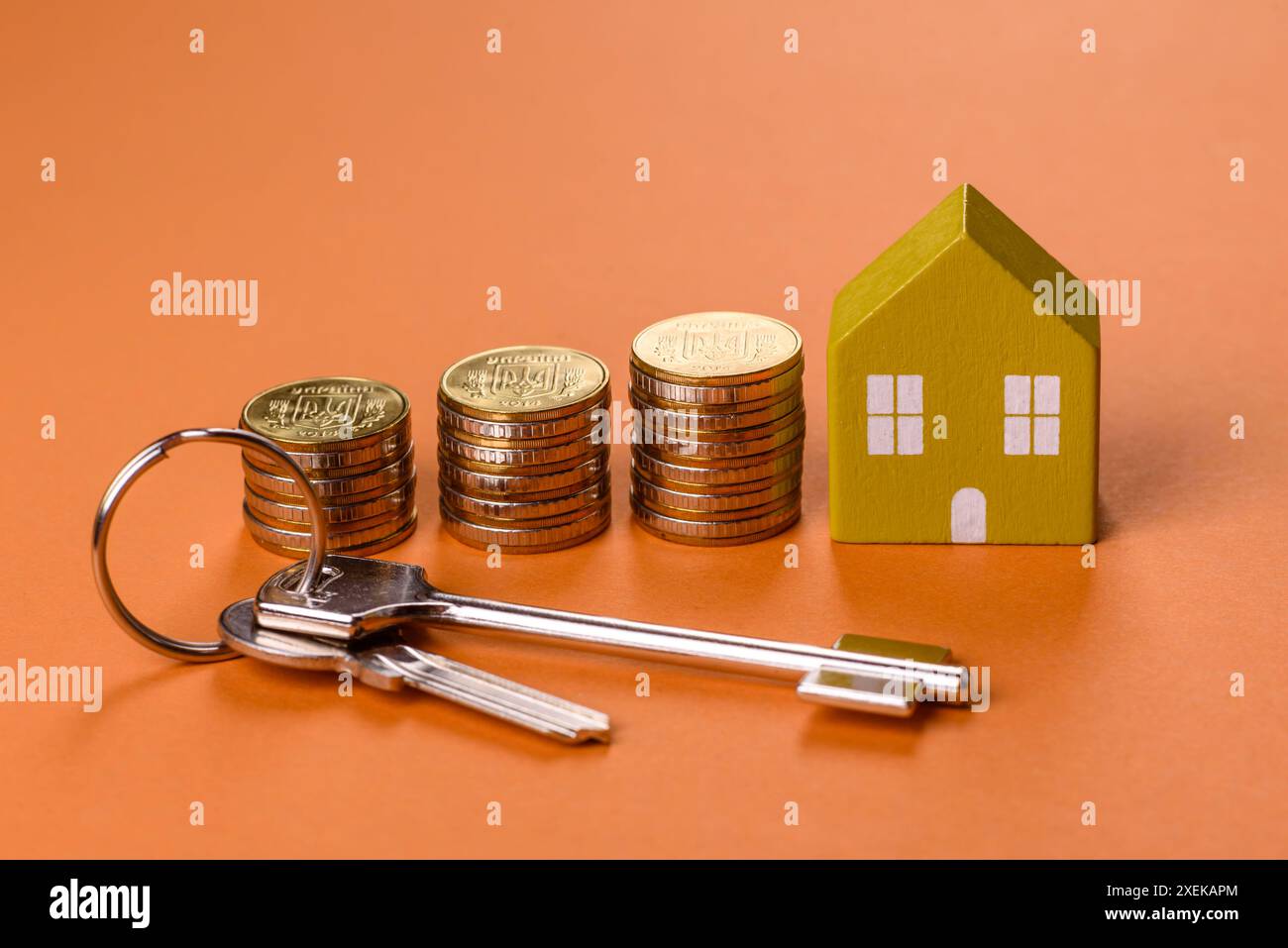 Una piccola casa di legno, soldi e chiavi come idea per investire nella propria casa Foto Stock