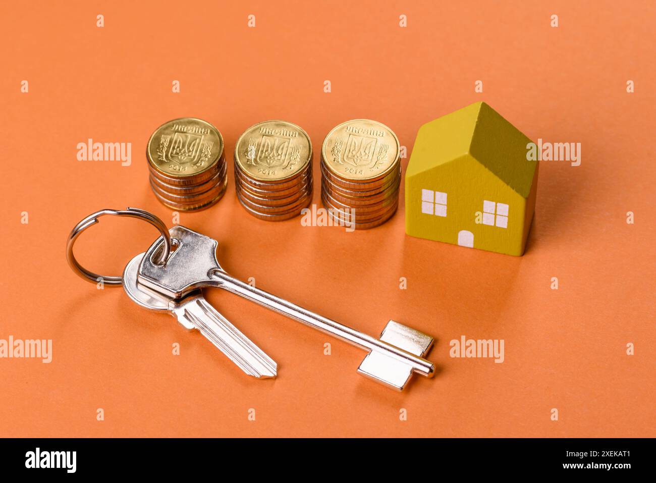Una piccola casa di legno, soldi e chiavi come idea per investire nella propria casa Foto Stock
