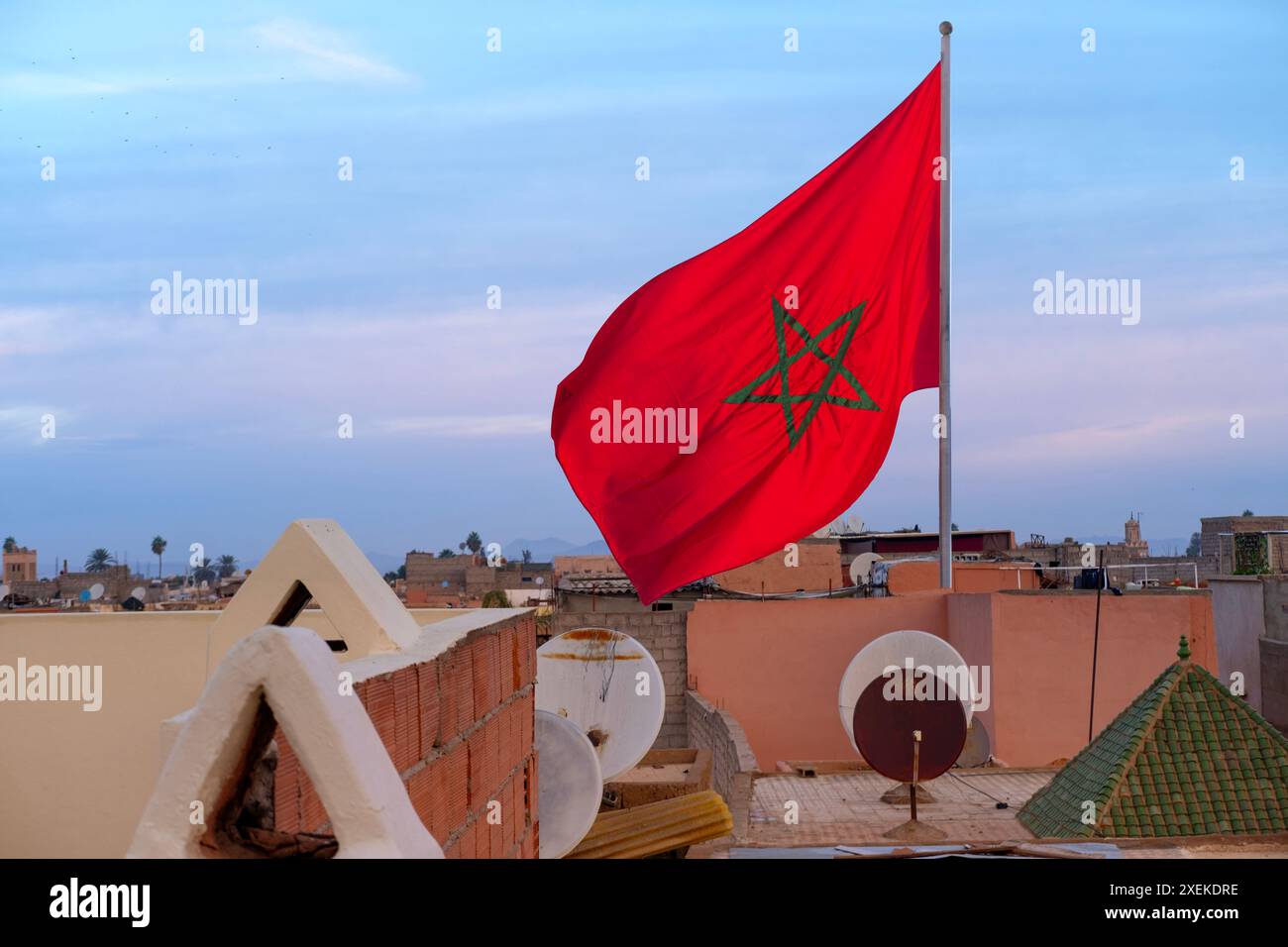 Bandiera marocchina rossa nazionale marocchina sventola un panno di seta contro il cielo, stella a cinque punte, edificio governativo, giornata dell'indipendenza, commercio globale, affari e cou Foto Stock