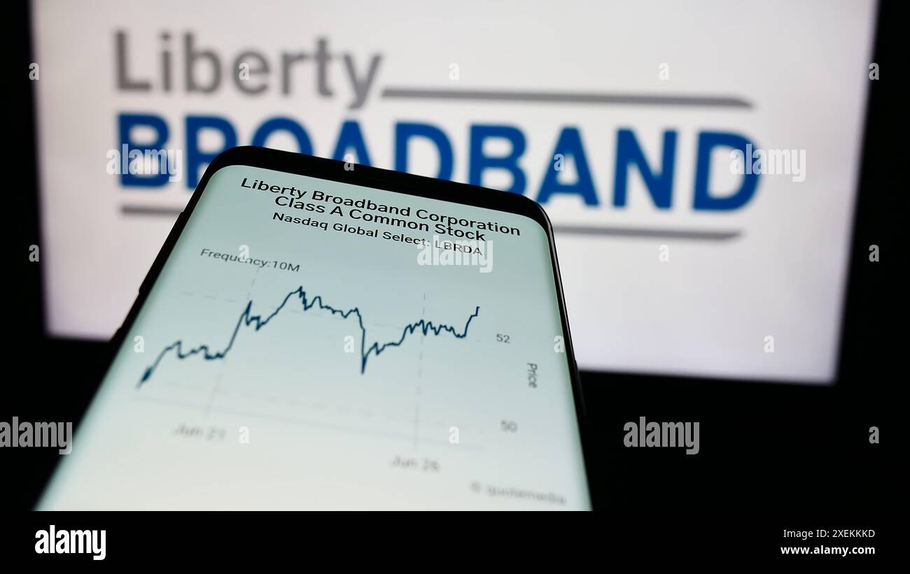 Smartphone con sito Web della società statunitense Liberty Broadband Corporation (LBRDA) davanti al logo aziendale. Mettere a fuoco in alto a sinistra sul display del telefono. Foto Stock