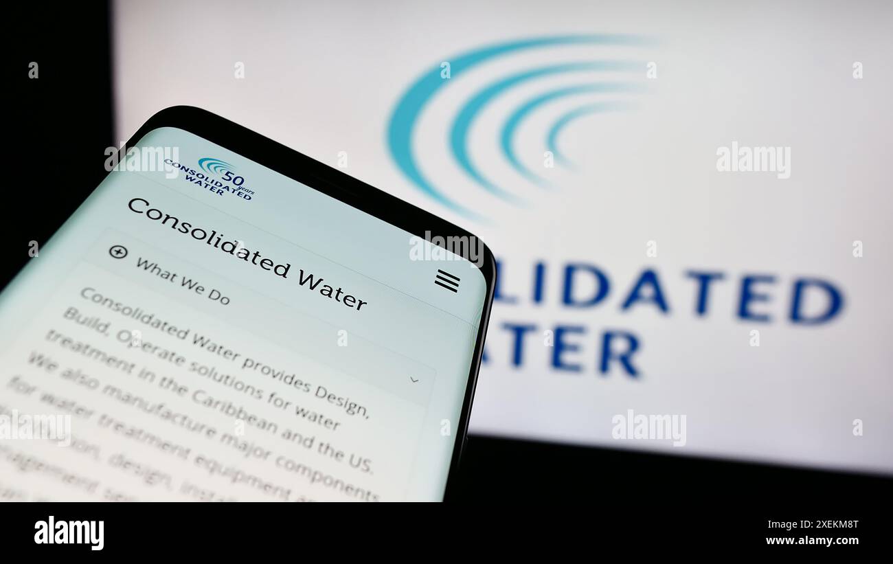 Smartphone con sito Web della società di desalinizzazione dell'acqua di mare Consolidated Water Co. Ltd. Davanti al logo. Mettere a fuoco in alto a sinistra sul display del telefono. Foto Stock