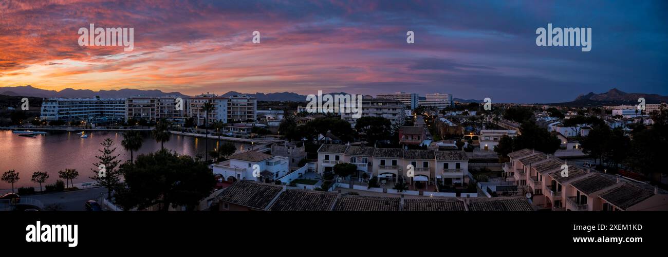 Vista del lago e degli appartamenti al tramonto; Port d'Alcudia, Isole Baleari, Spagna Foto Stock