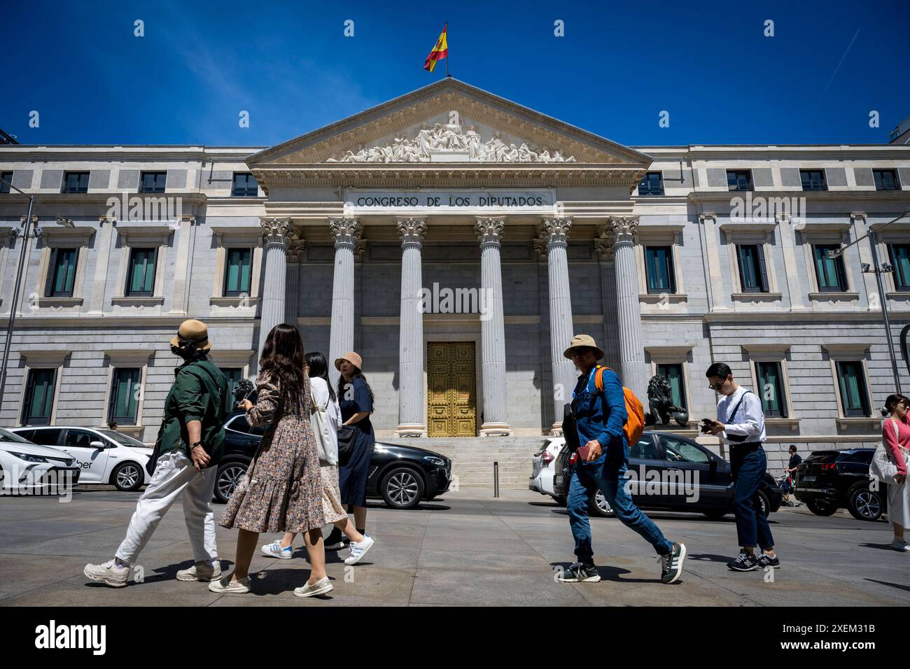 Pedoni e veicoli sulla strada di fronte al Palacio de las Cortes a Madrid; Madrid, Spagna Foto Stock
