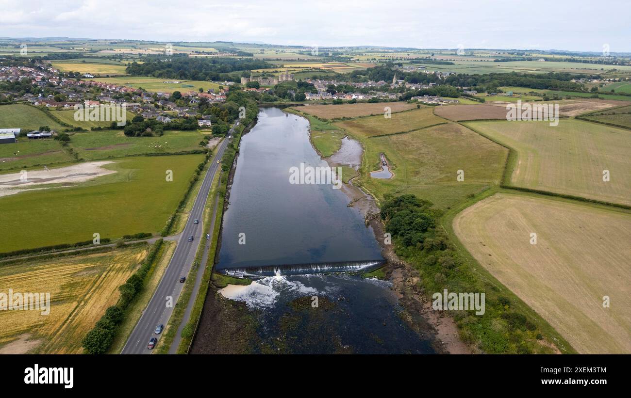 Vista aerea del fiume Coquet a Amble e del castello di Warkworth in lontananza, Northumberland, Inghilterra. Foto Stock