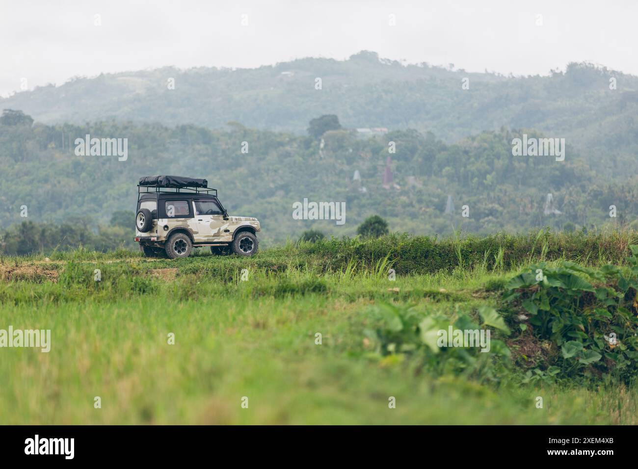 Veicolo sportivo parcheggiato presso Air Terjun Kacura (cascata di Kacura) in Indonesia Foto Stock