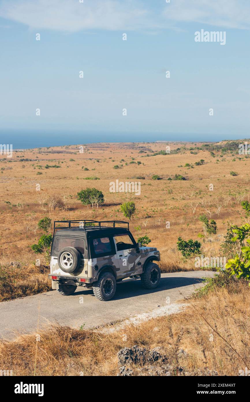 SUV parcheggiato su strada a Savana Puru Kambera, Indonesia; Mondu, Kecamatan Kanatang, Kabupaten Sumba Timur, Nusa Tenggara Timur, Indonesia Foto Stock