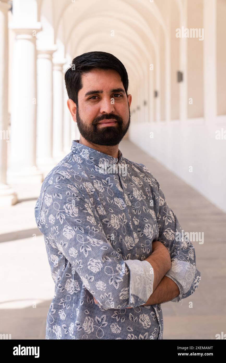 Primo piano ritratto di un pakistano con barba scura e vestiti di colore chiaro. Uomo che guarda la telecamera Foto Stock