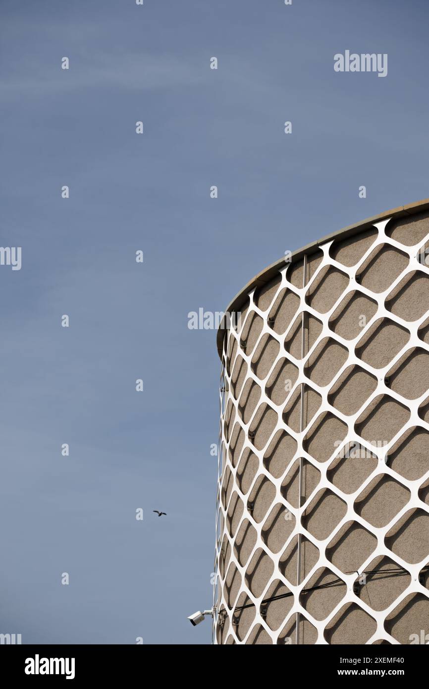Un futuristico edificio cilindrico squisitamente decorato con elementi architettonici in metallo. Foto Stock