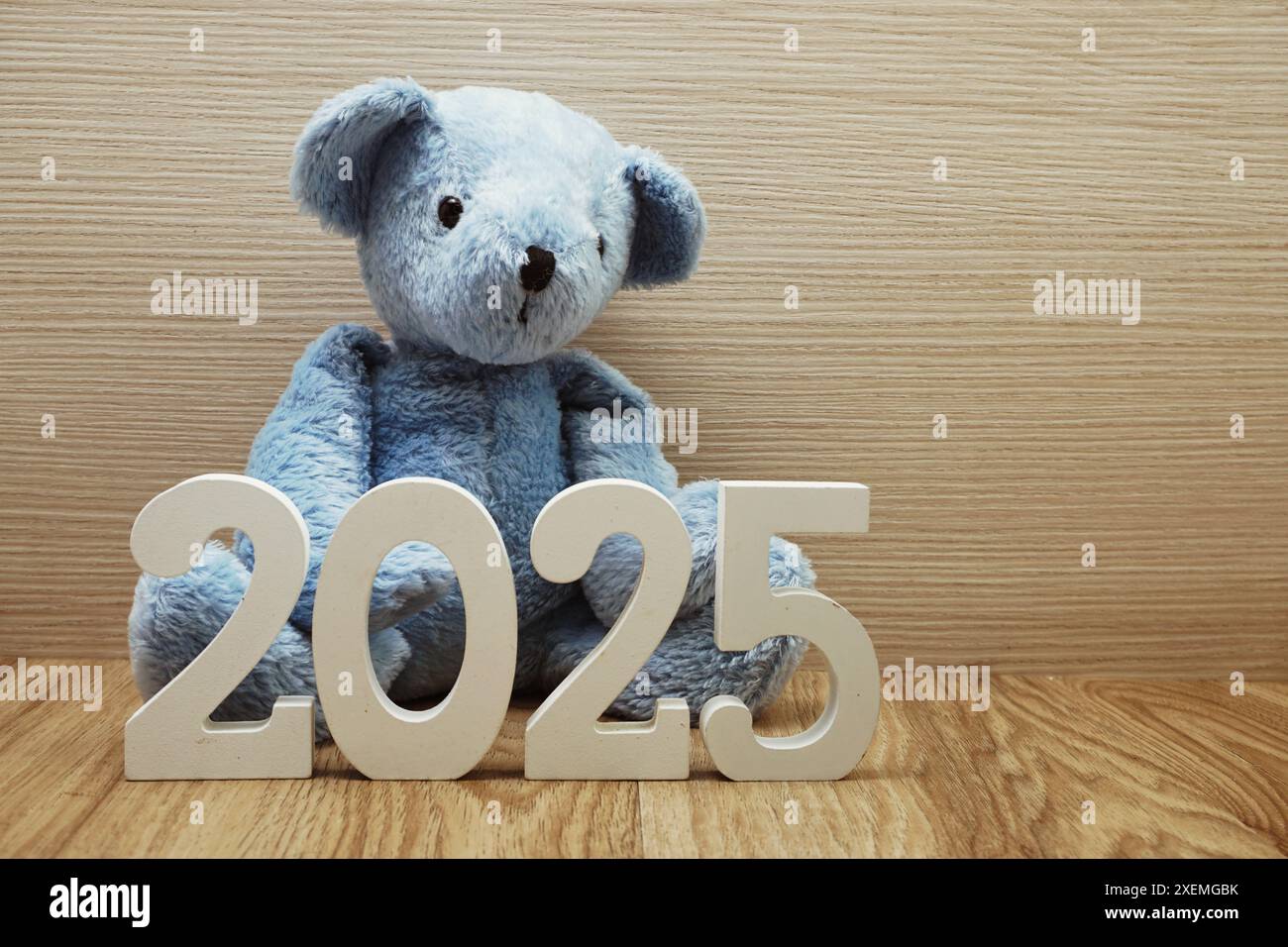 Felice anno nuovo 2025 sfondo festivo con decorazioni in orsacchiotto su sfondo in legno Foto Stock