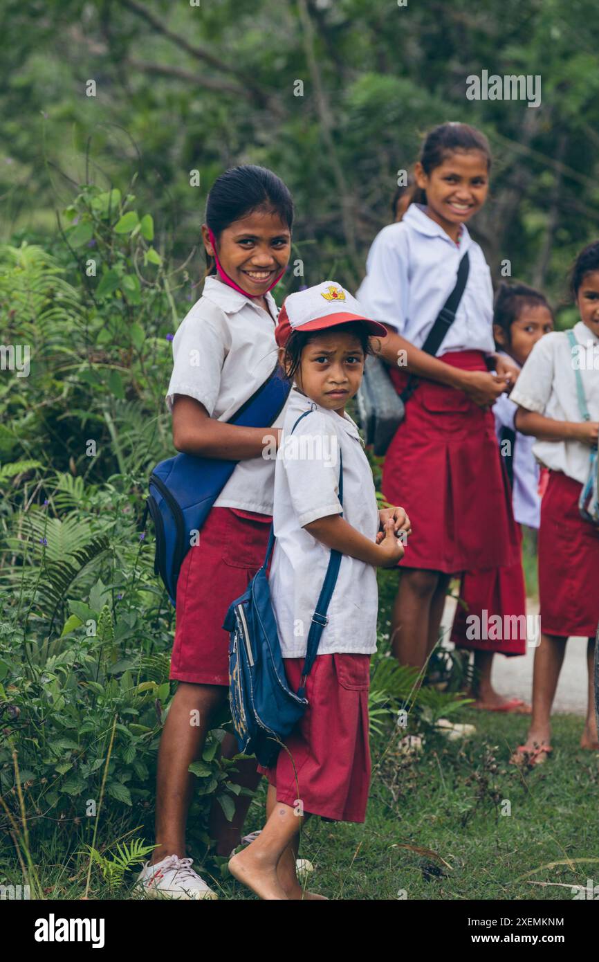 I bambini delle scuole stanno insieme su una strada a West Sumba Regency, Indonesia; West Sumba Regency, East Nusa Tenggara, Indonesia Foto Stock
