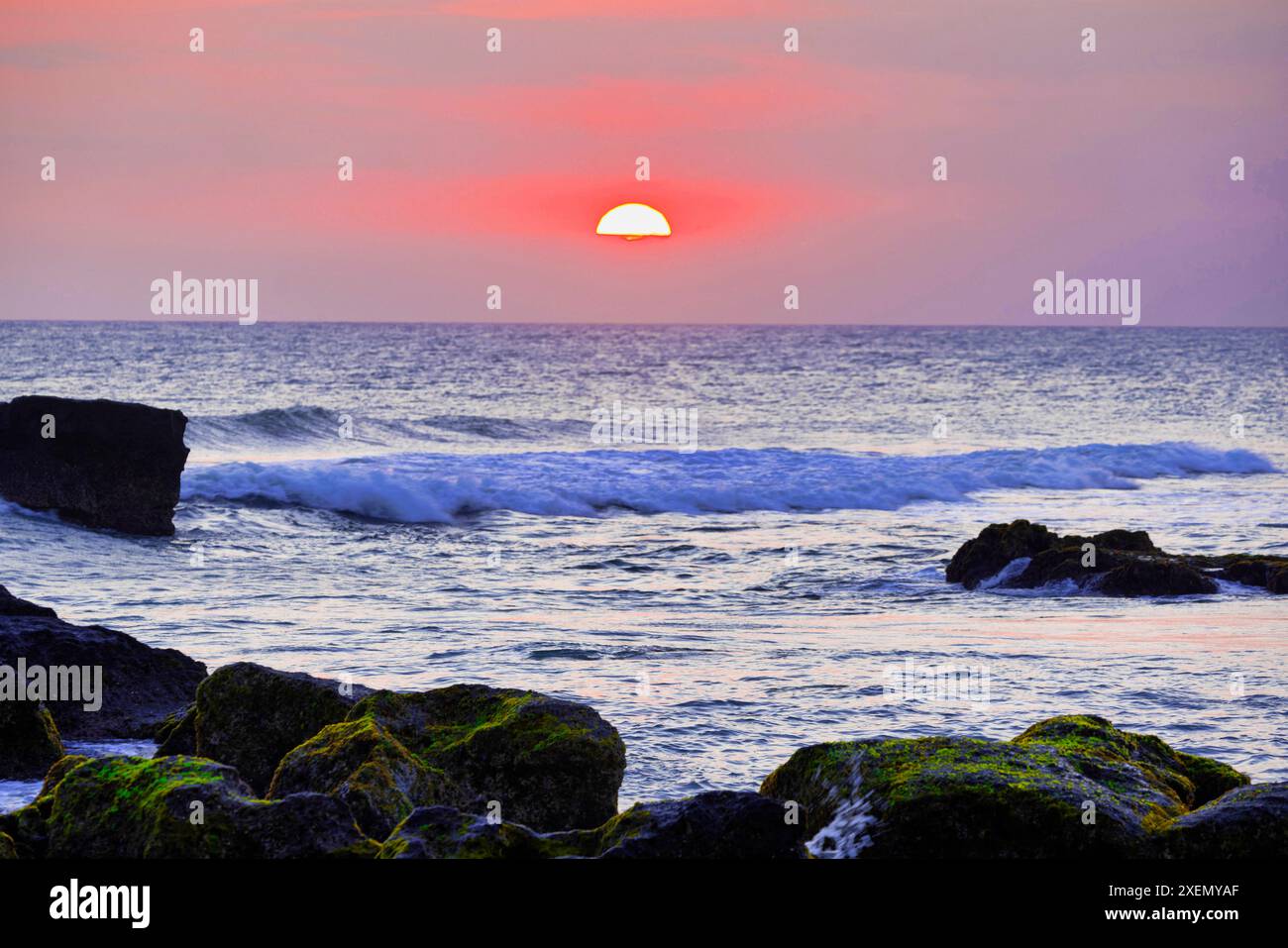 Tramonto sull'Oceano Indiano con isolotti di roccia lavica in primo piano Foto Stock