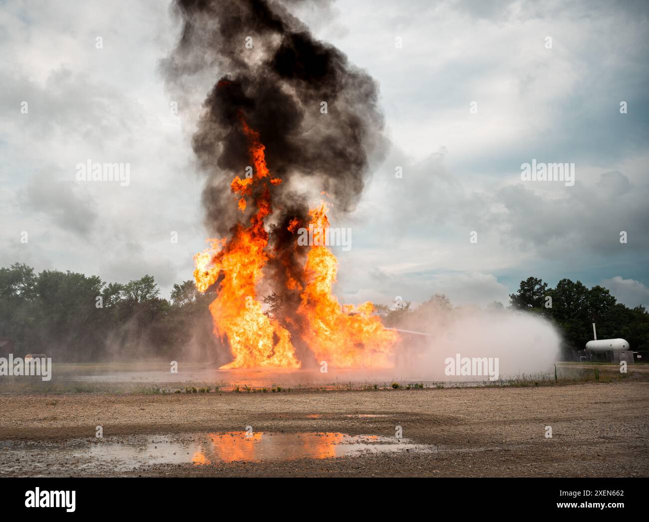 Un addestratore di aerei viene messo in fiamme durante un'esercitazione antincendio presso la Joint base Langley-Eustis, Virginia, il 27 giugno 2024. Questo esercizio non era solo un'opportunità di formazione per il reparto dei vigili del fuoco del 633d Civil Engineer Squadron, ma era anche visto dai cadetti del Junior Reserve Officers' Training Corps provenienti da oltre otto distretti scolastici. Questa dinamica ha evidenziato l’importanza dell’impegno comunitario e della cooperazione militare coinvolgendo gli studenti di Hampton Roads. (Foto U.S. Air Force del Senior Airman Mikaela Smith) Foto Stock