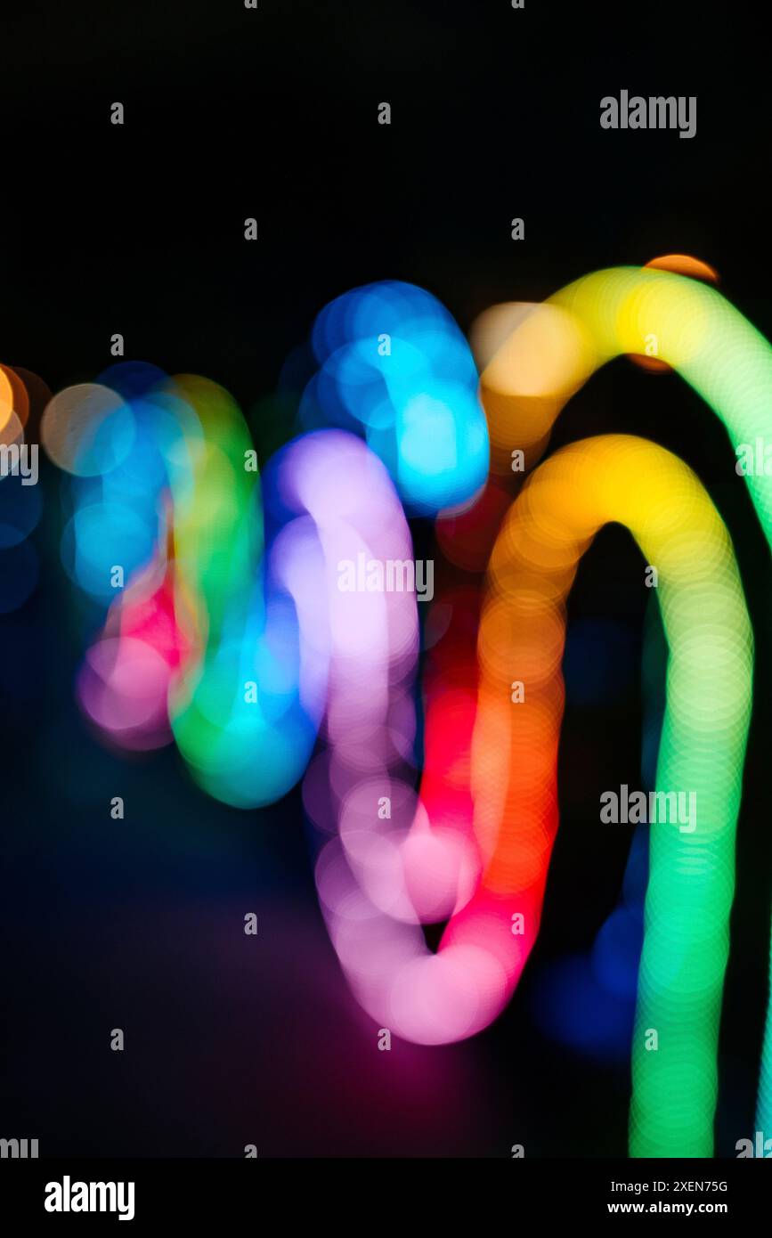 Luci sfocate e multicolore di un'installazione artistica che si snoda contro un cielo notturno; Bangkok, Thailandia Foto Stock