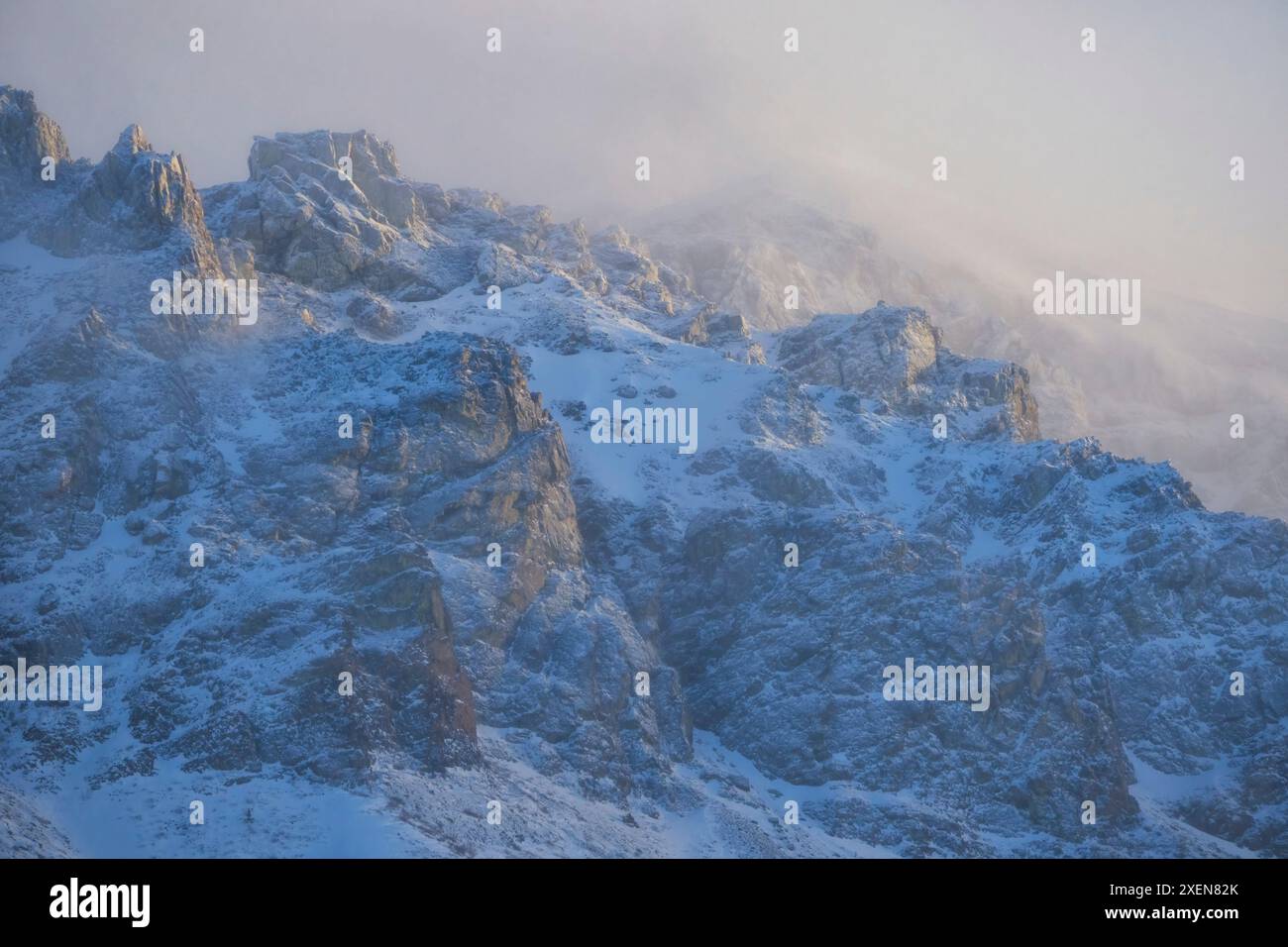 L'inverno si svolge nello Yukon mentre le nuvole nebbiose coprono le scoscese montagne che circondano il lago Annie si animano nella neve sublime e nella luce Foto Stock