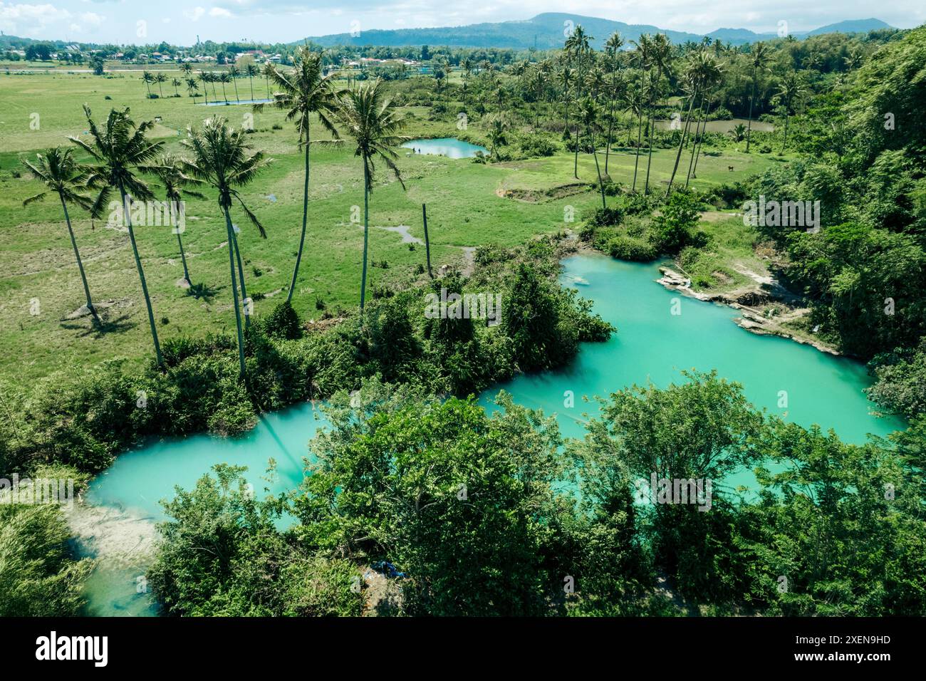 Vista dei laghi sulfurei (Ranolewo, una destinazione turistica), terreni agricoli e vegetazione lussureggiante su un'isola nel nord di Sulawesi, Indonesia Foto Stock