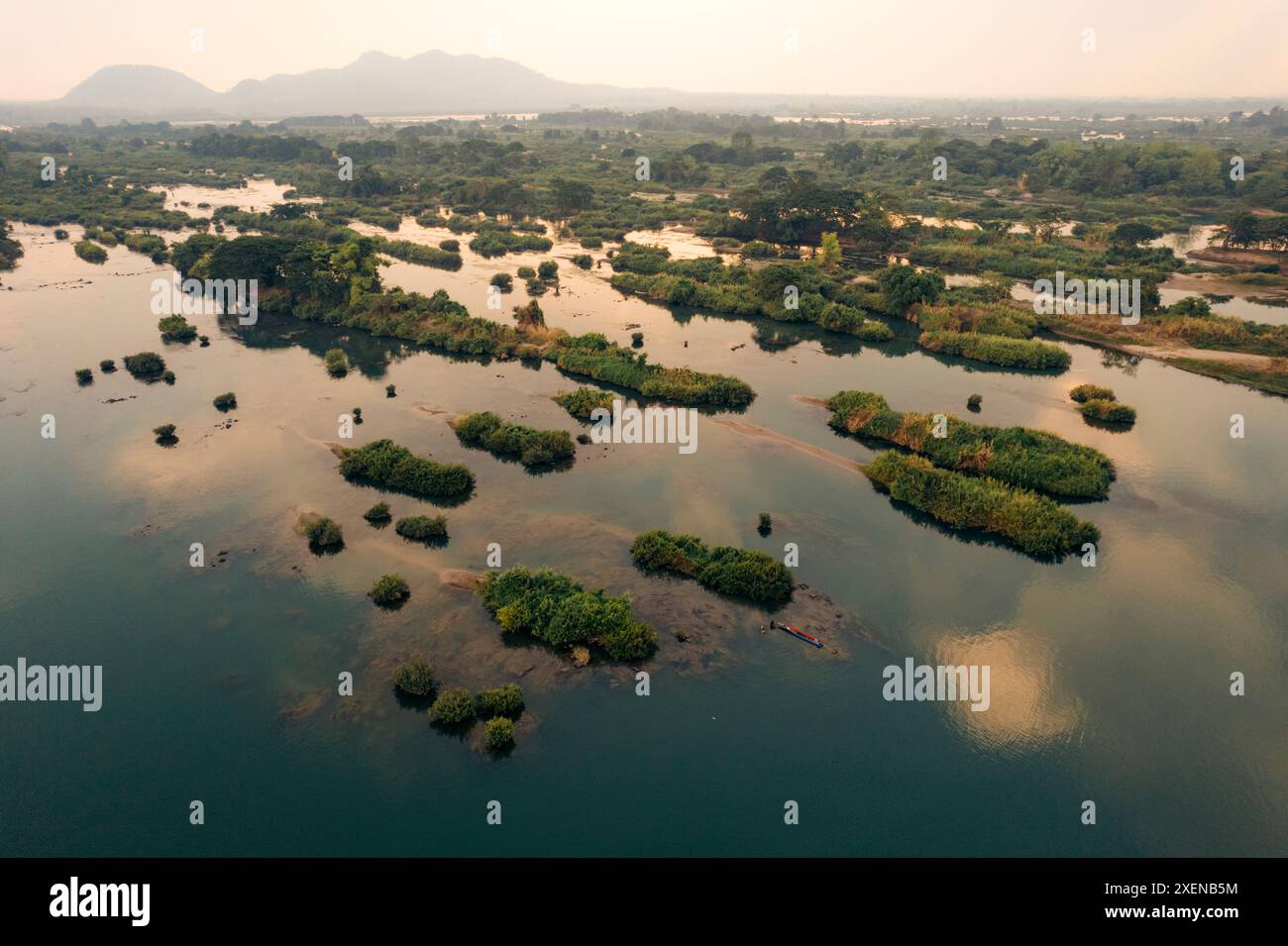 Piccole isole con vegetazione verde in acque limpide al crepuscolo nella zona di quattromila isole (si Phan Don) nel Laos meridionale Foto Stock