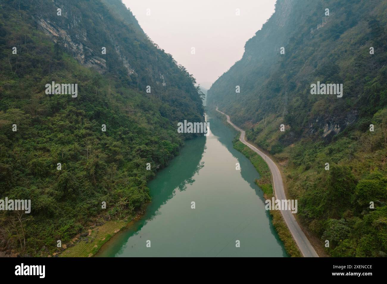 Strada e vegetazione lussureggiante lungo il bellissimo fiume Gam a Cao Bang, Vietnam; Ly Bon, Bao Lam District, Cao Bang, Vietnam Foto Stock