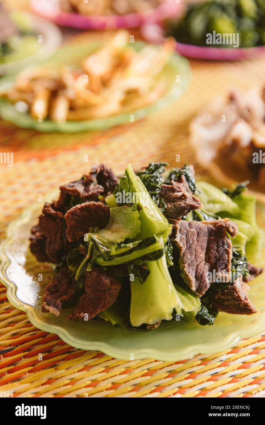 Cucina tradizionale in Vietnam con carne e verdure frondose; Ban Nam Nghiep, Muong la, Son la, Vietnam Foto Stock