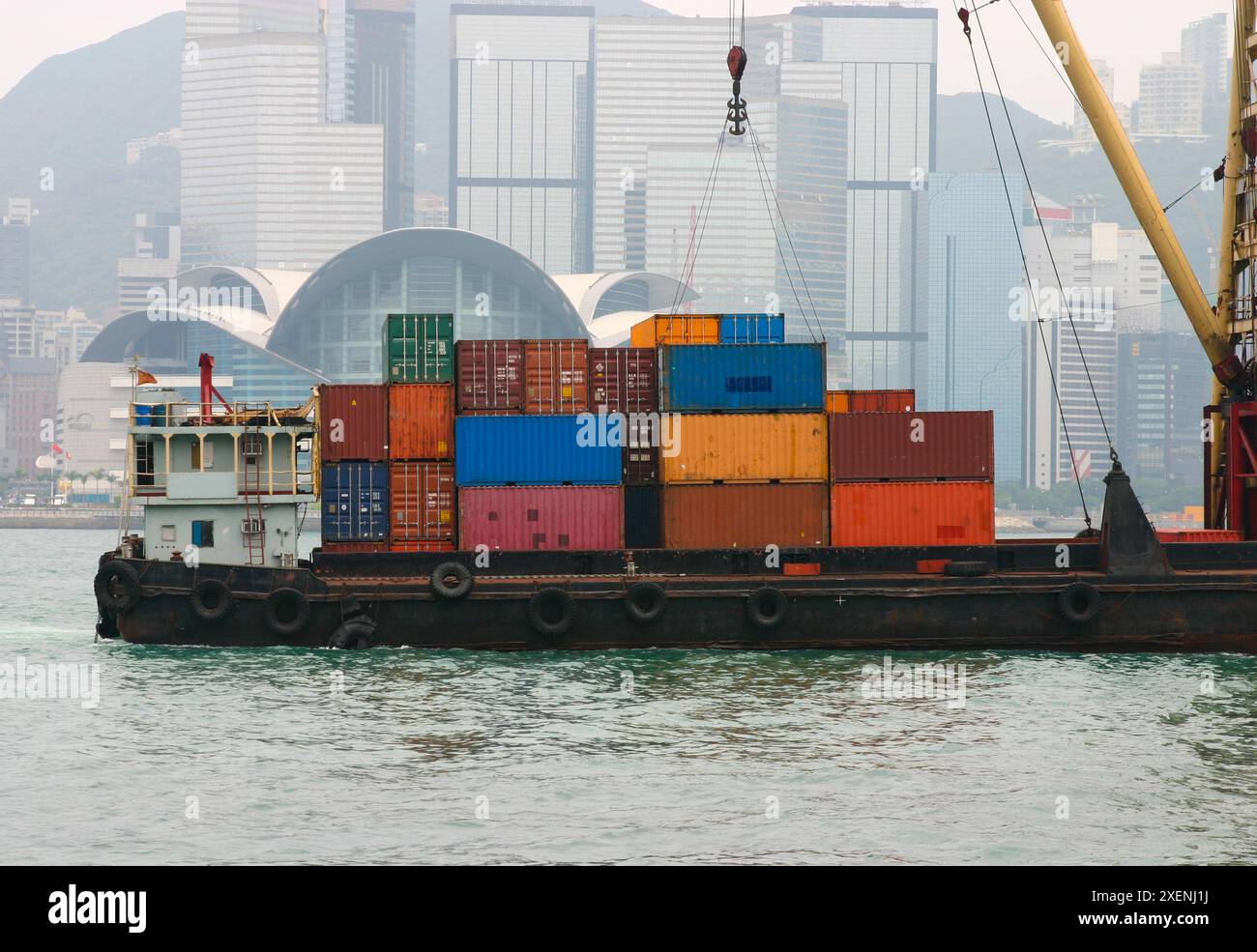 Una chiatta portacontainer trasporta container nel Victoria Harbour - Hong Kong. Hong Kong è sede di uno dei porti marittimi più trafficati. Foto Stock