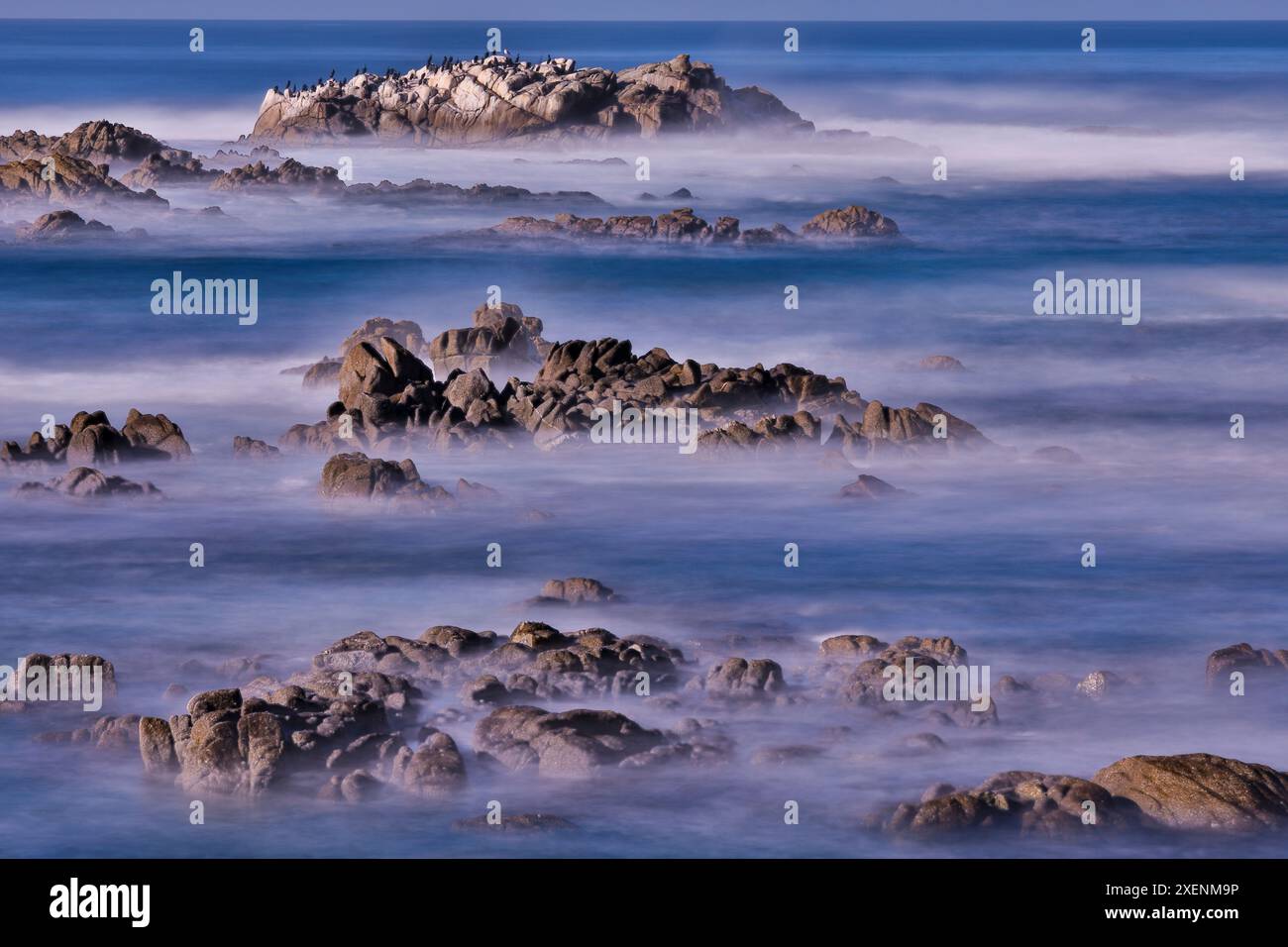USA, California, Pacific Grove. Monterey Bay, surf che si schianta su rocce Foto Stock
