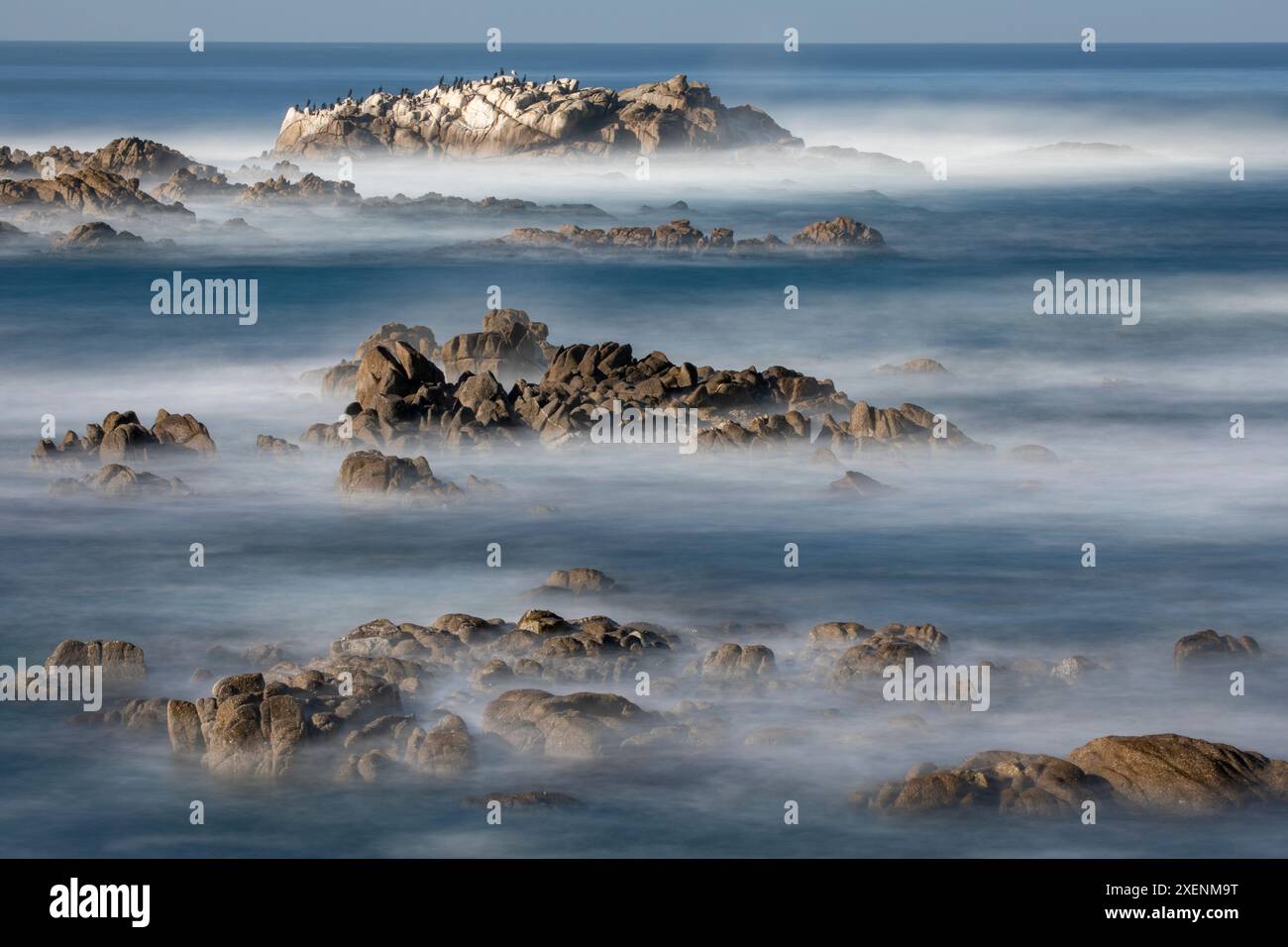 USA, California, Pacific Grove. Monterey Bay, surf che si schianta su rocce Foto Stock