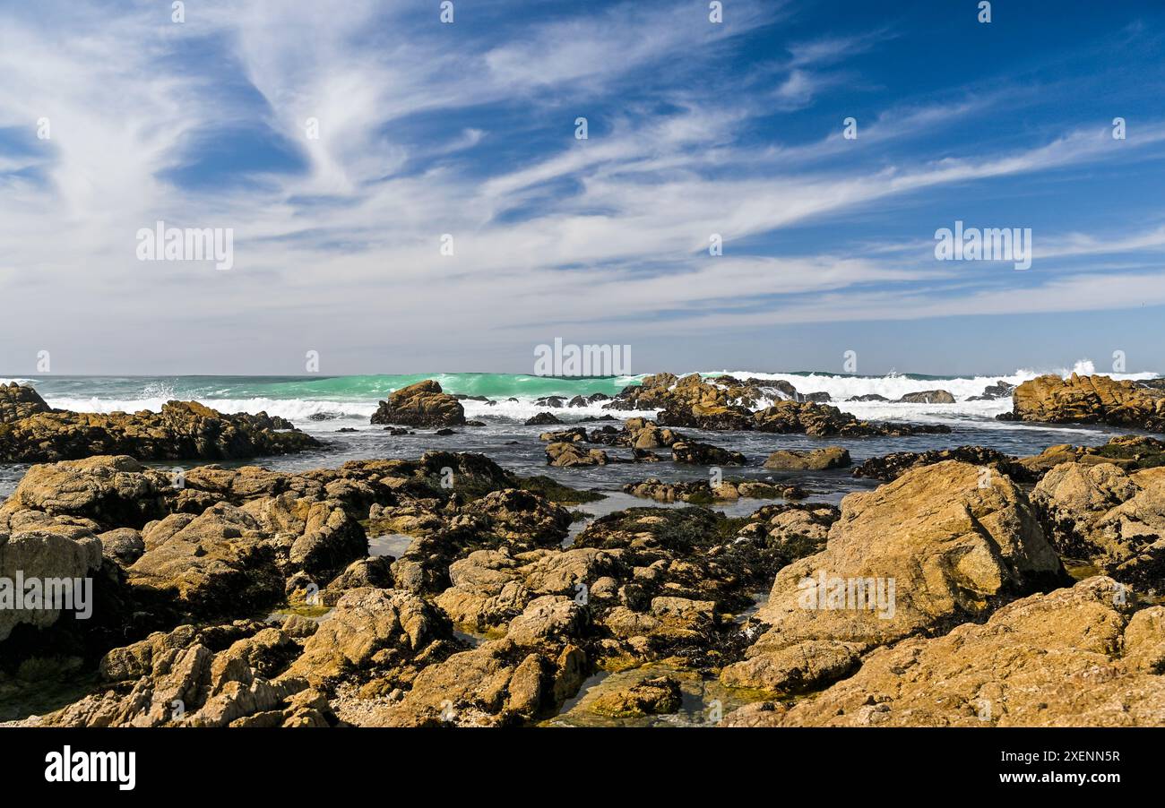 Onde che si infrangono sulle rocce granitiche della costa pacifica della baia di Monterey in una splendida giornata. Foto Stock