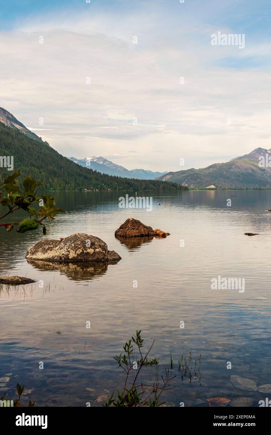 Una foto verticale di massi nel lago Wenatchee, Washington, con le Cascade Mountains sullo sfondo. Foto Stock