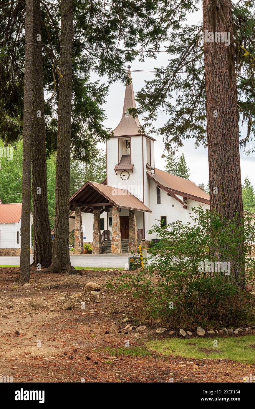 La Plain Community Church, con la sua architettura in stile bavarese e il campanile, è incorniciata da un gruppo di alberi sempreverdi nel villaggio di Plain, Washi Foto Stock