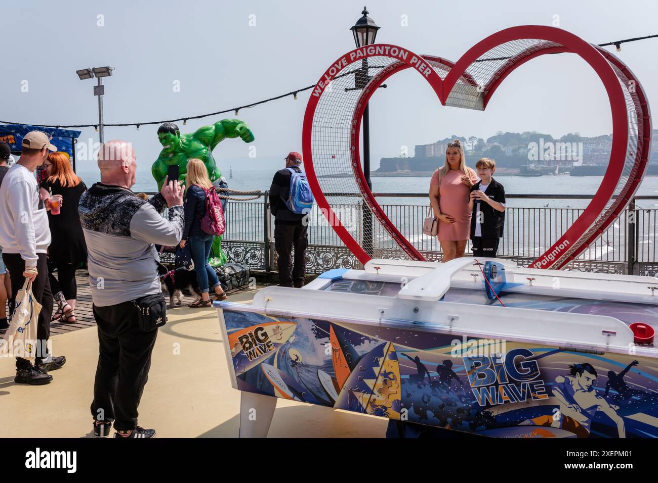 I turisti che si pongono per una foto al Paignton Pier, Devon Foto Stock
