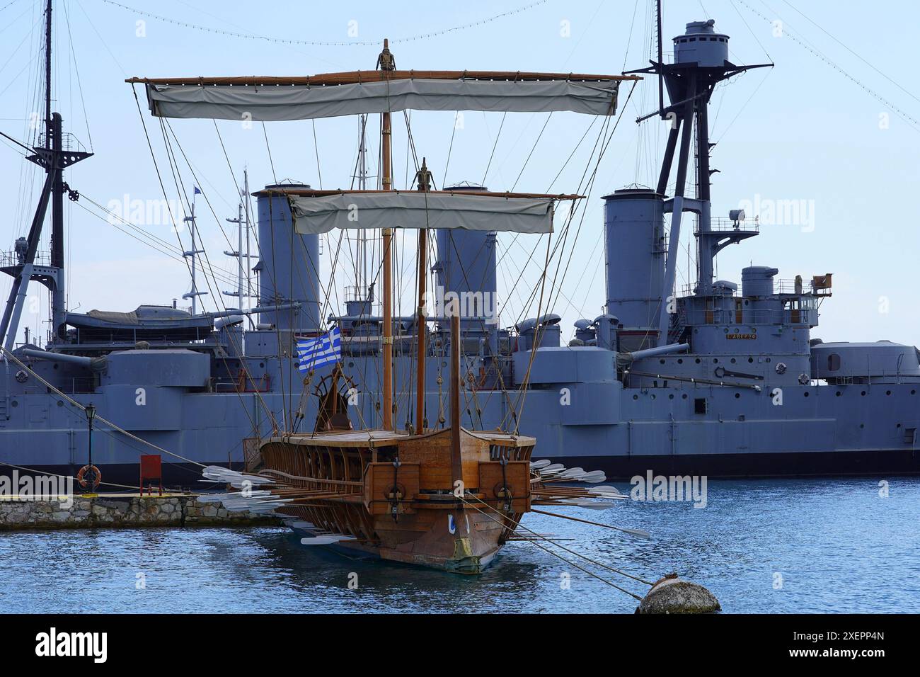 Una trireme, un'antica replica in scala reale, di fronte ad un vecchio incrociatore, a Faliro, Attica, Grecia Foto Stock