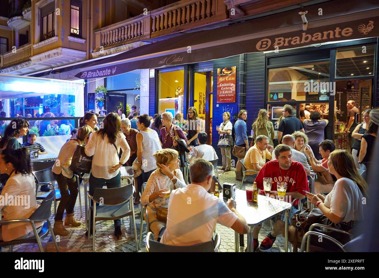 Persone che bevono vino e mangiano tapas in un bar, 'pintxo pote', quartiere Gros, Donostia (San Sebastian), Gipuzkoa, paesi Baschi, Spagna Foto Stock