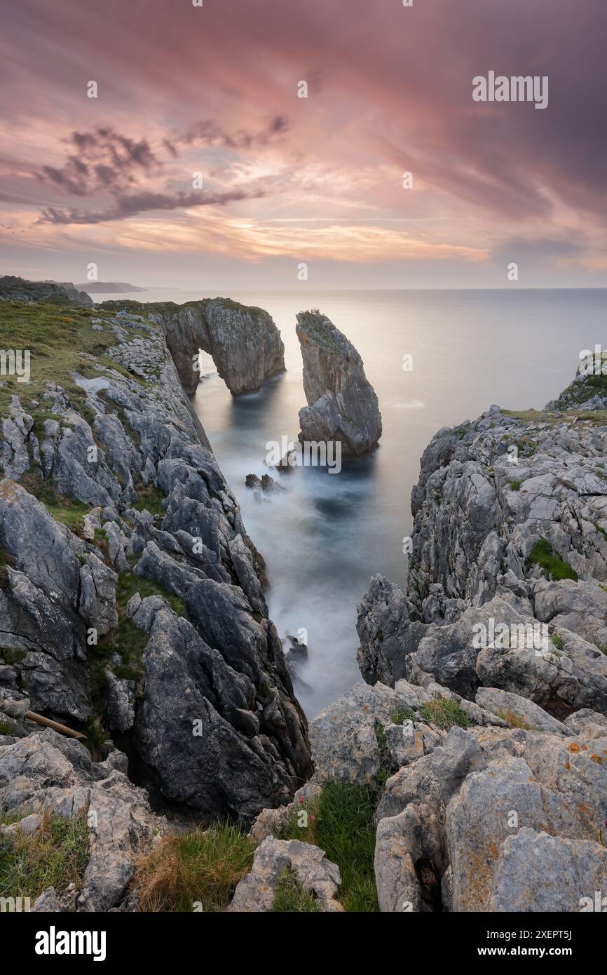 Tramonto sulle scogliere di Infierno con il suo caratteristico punto di riferimento roccioso, nella zona di Ribadesella, Asturie, Spagna Foto Stock
