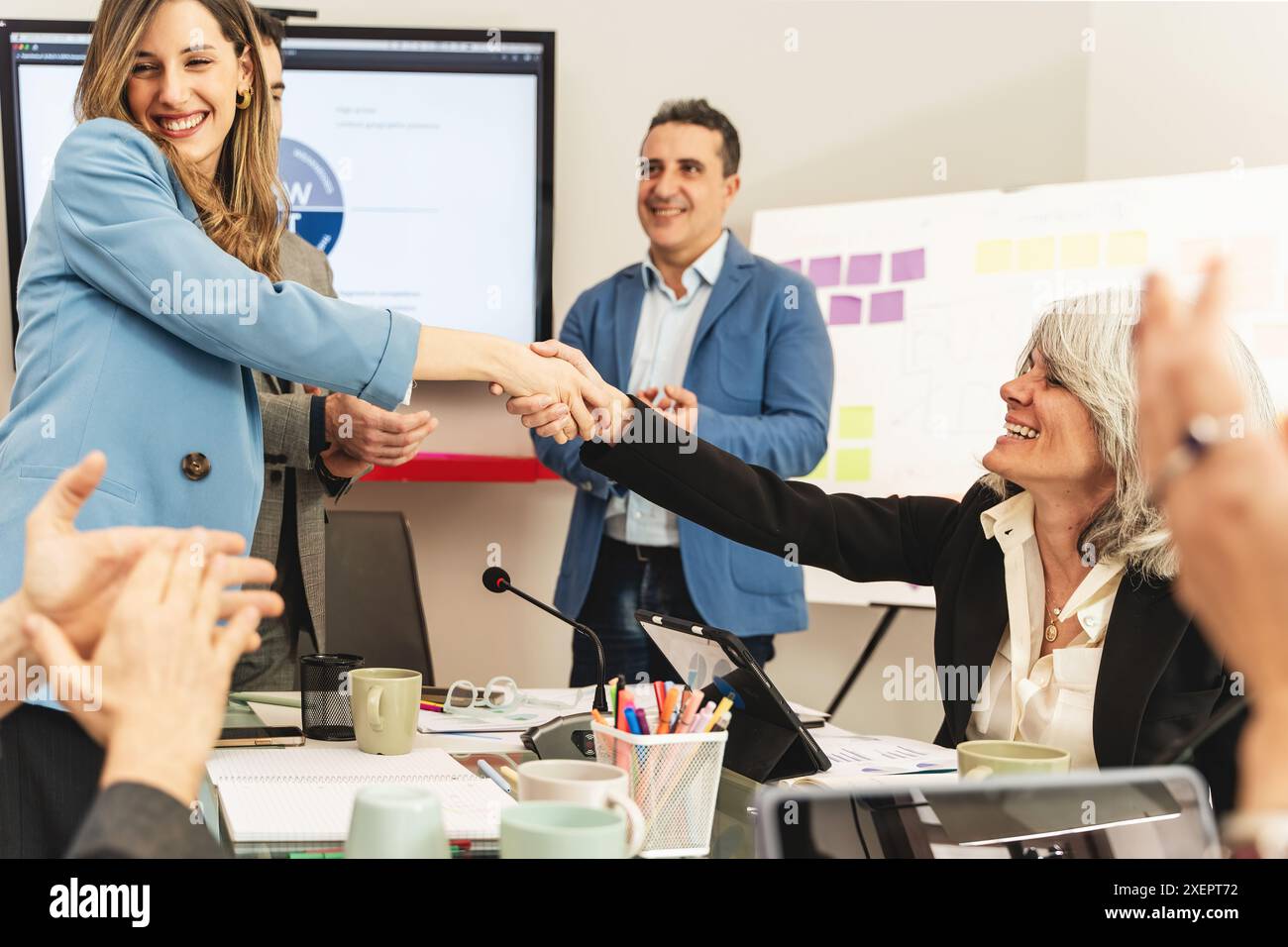 Stretta di mano professionale in una riunione. Team che celebra la collaborazione e l'accordo di successo. Ambiente d'ufficio con professionisti soddisfatti. Foto Stock