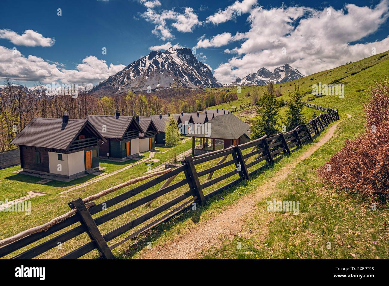 Tranquillo rifugio di campagna con incantevoli chalet e cabine in legno, circondato da alberi autunnali e viste panoramiche delle montagne, offre la sistemazione perfetta Foto Stock