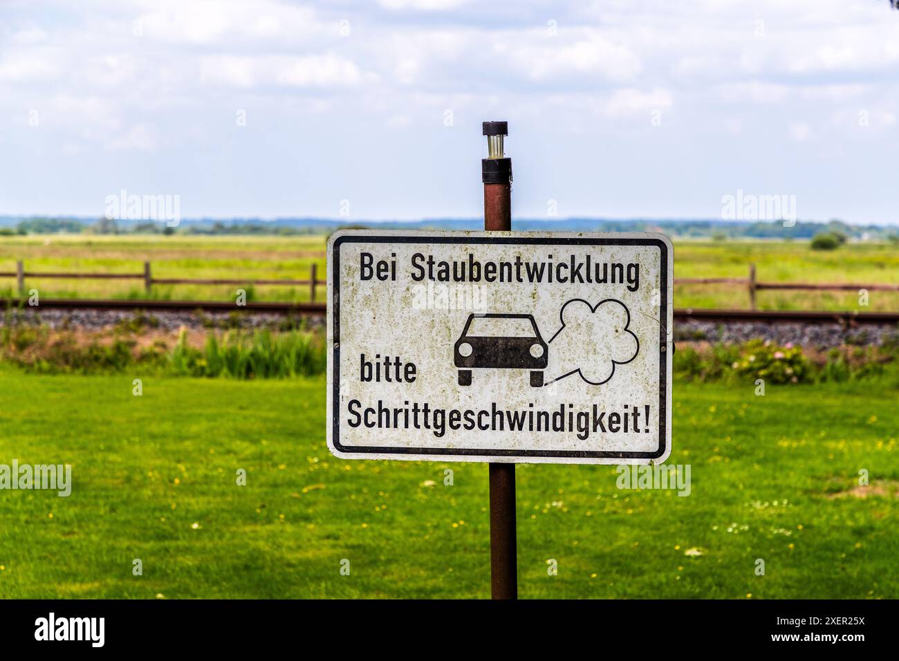 Il segnale di avvertimento su un percorso di ghiaia si traduce in: Guidare a velocità sostenuta quando si genera polvere. Worpswede, bassa Sassonia, Germania Foto Stock