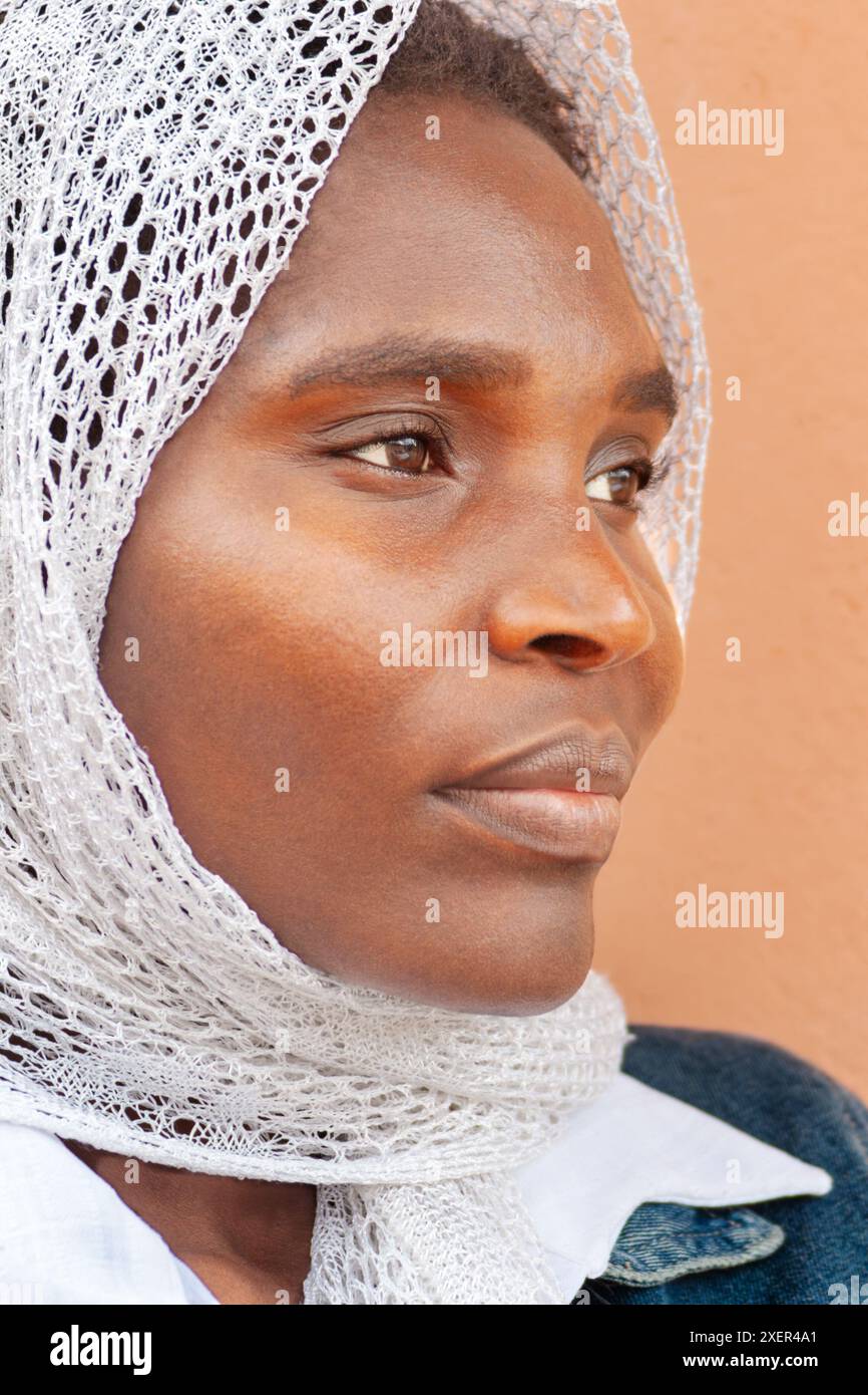 profilo giovane donna africana con velo all'aperto, giacca in denim Foto Stock