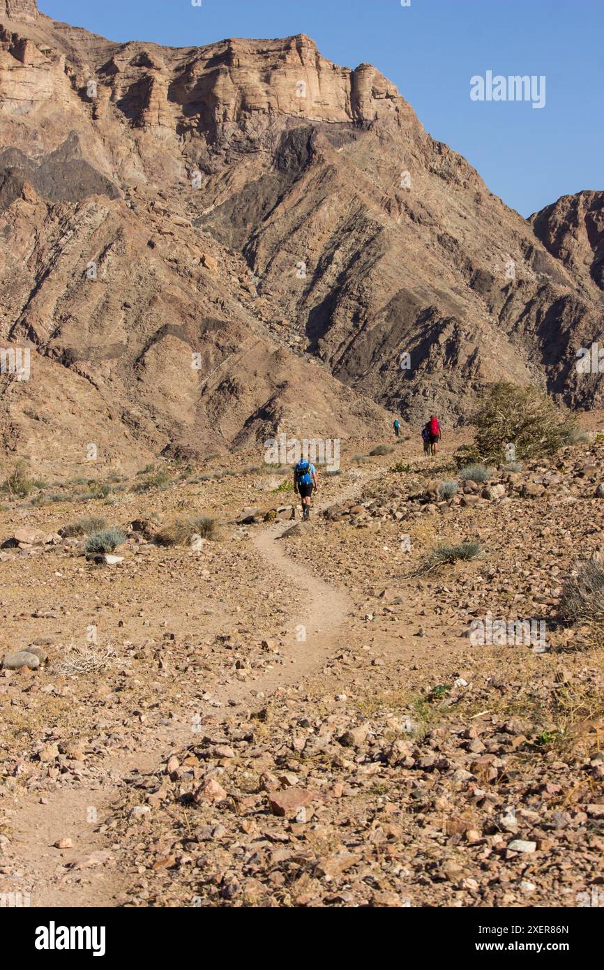 Escursionisti su un sentiero, tra piccole rocce nel paesaggio arido del Fish River Canyon Foto Stock