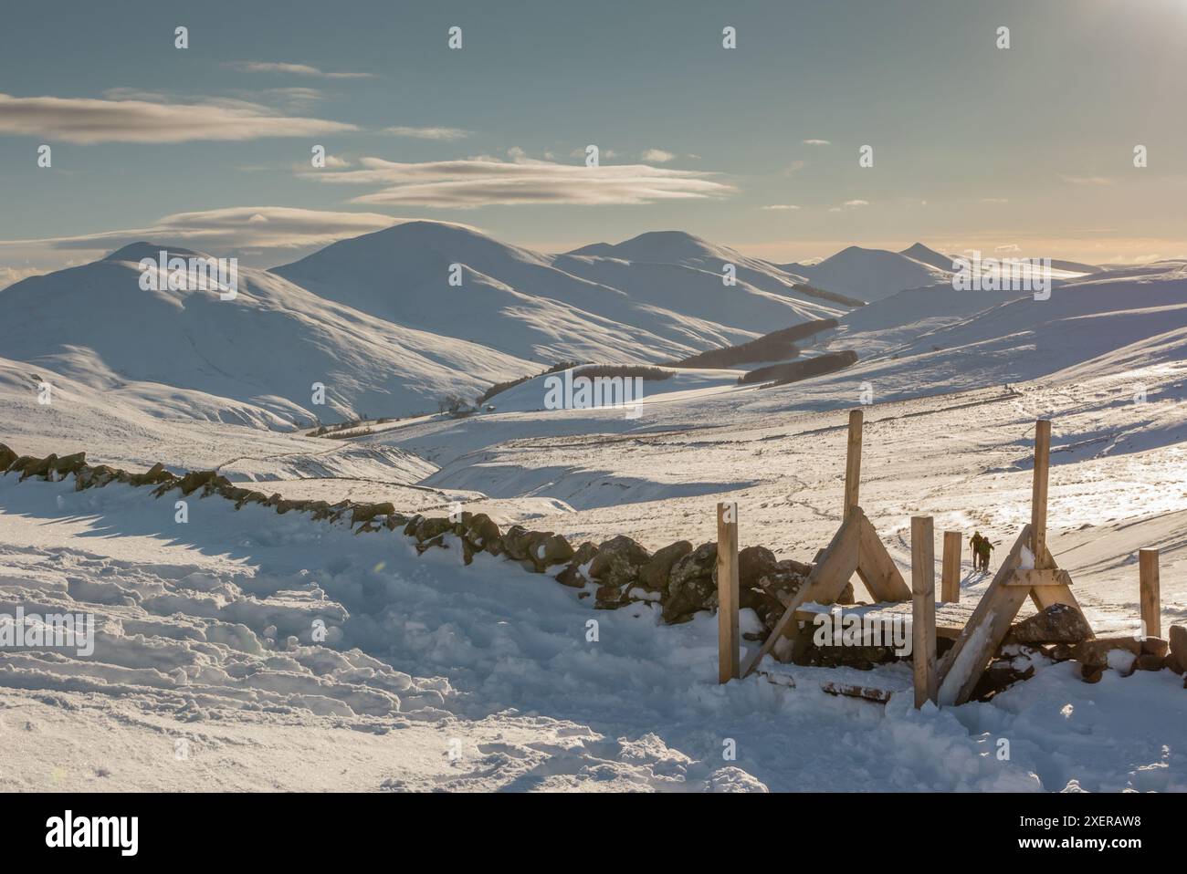 Paesaggio invernale di montagne innevate nelle Pentland Hills di Edimburgo, in Scozia, in una giornata invernale soleggiata con pareti in pietra e stile in legno Foto Stock