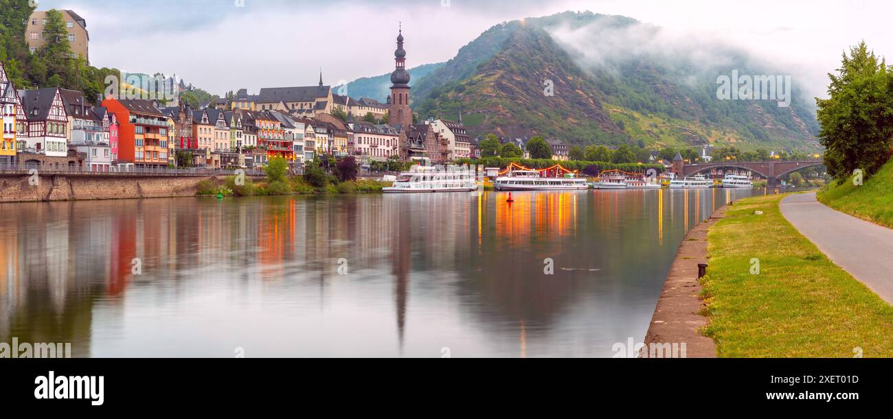 Vista serale della città di Cochem con edifici colorati e una chiesa lungo il fiume Mosella, Germania Foto Stock